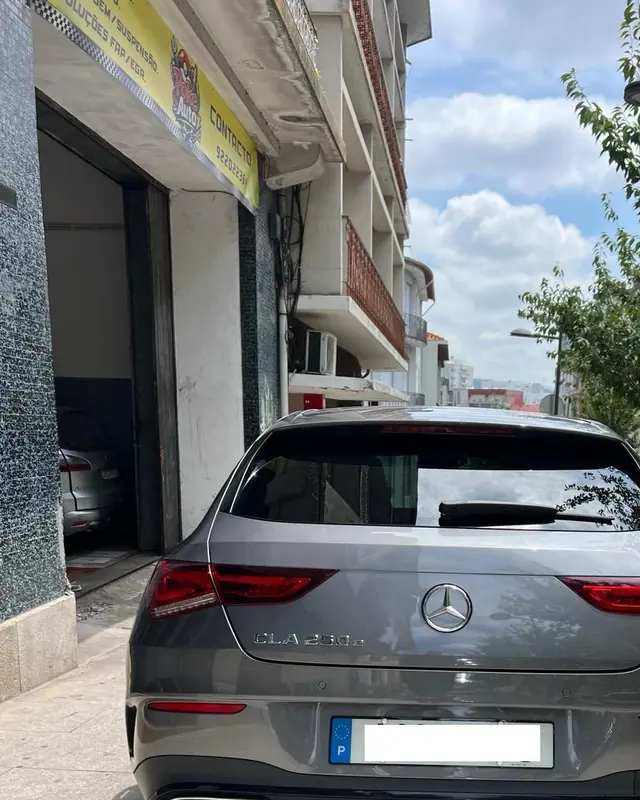 Carro à porta da oficina, na Rua da Liberdade, 53